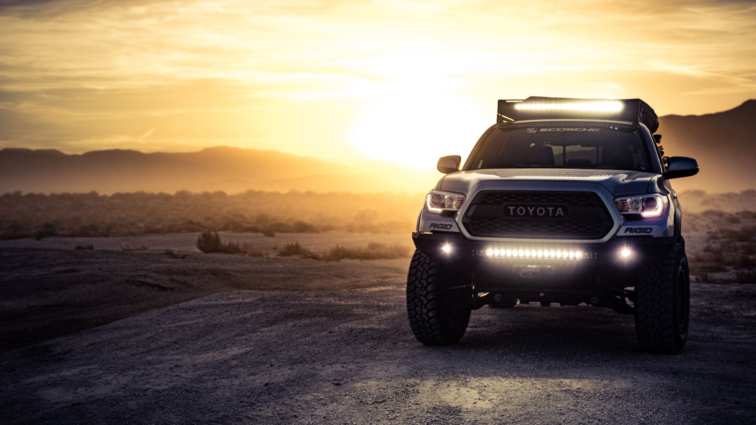 Overland Toyota pickup with light bar at sunset on a desert trail